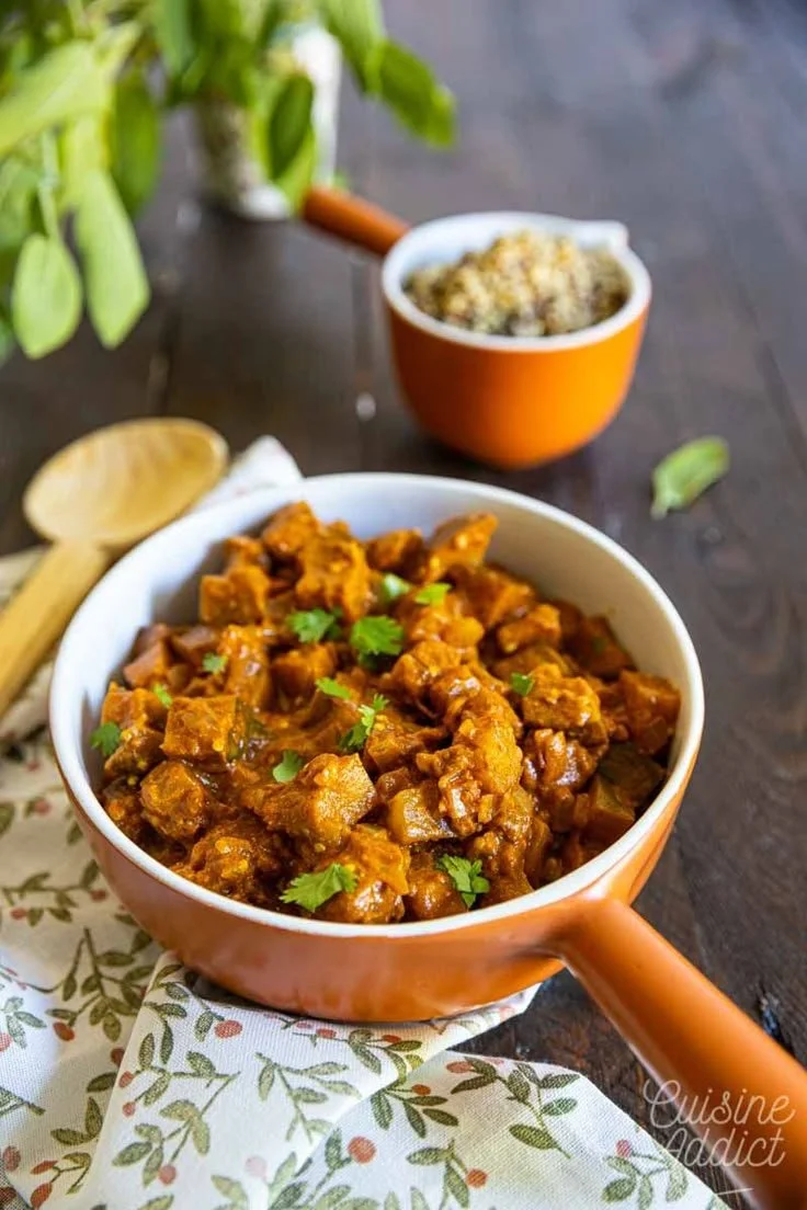 Plat de curry d'aubergines épicé et coloré, prêt à être servi.