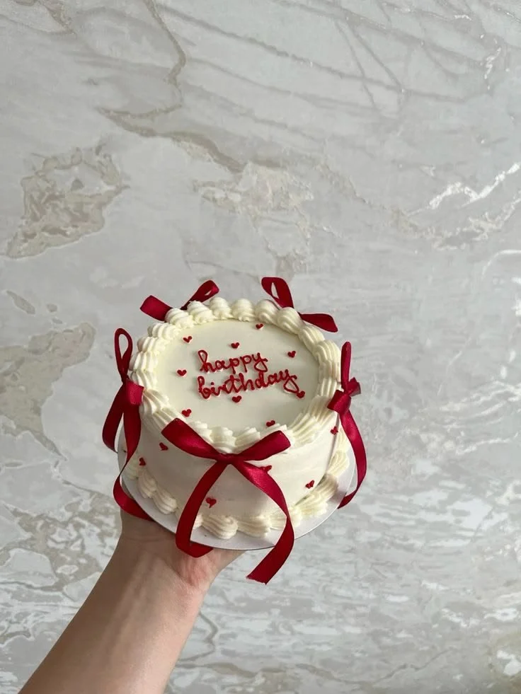Gâteau anniversaire romantique rouge et blanc, idéal pour les célébrations.